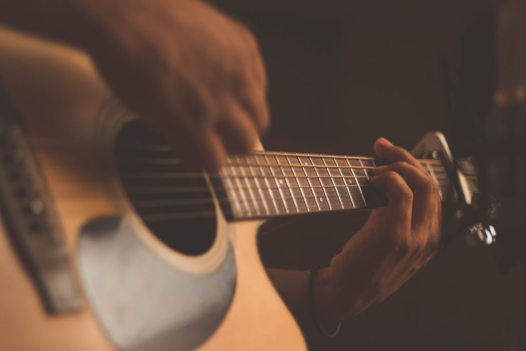 Close up of hands playing acoustic guitar. Image by Jefferson Santos