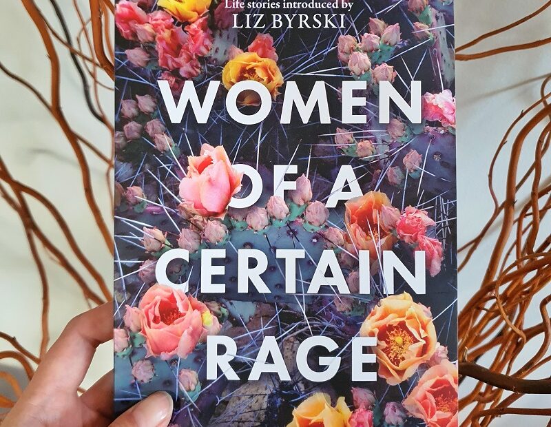 Book "Women of a Certain Rage" held in front of tangle of willow sticks
